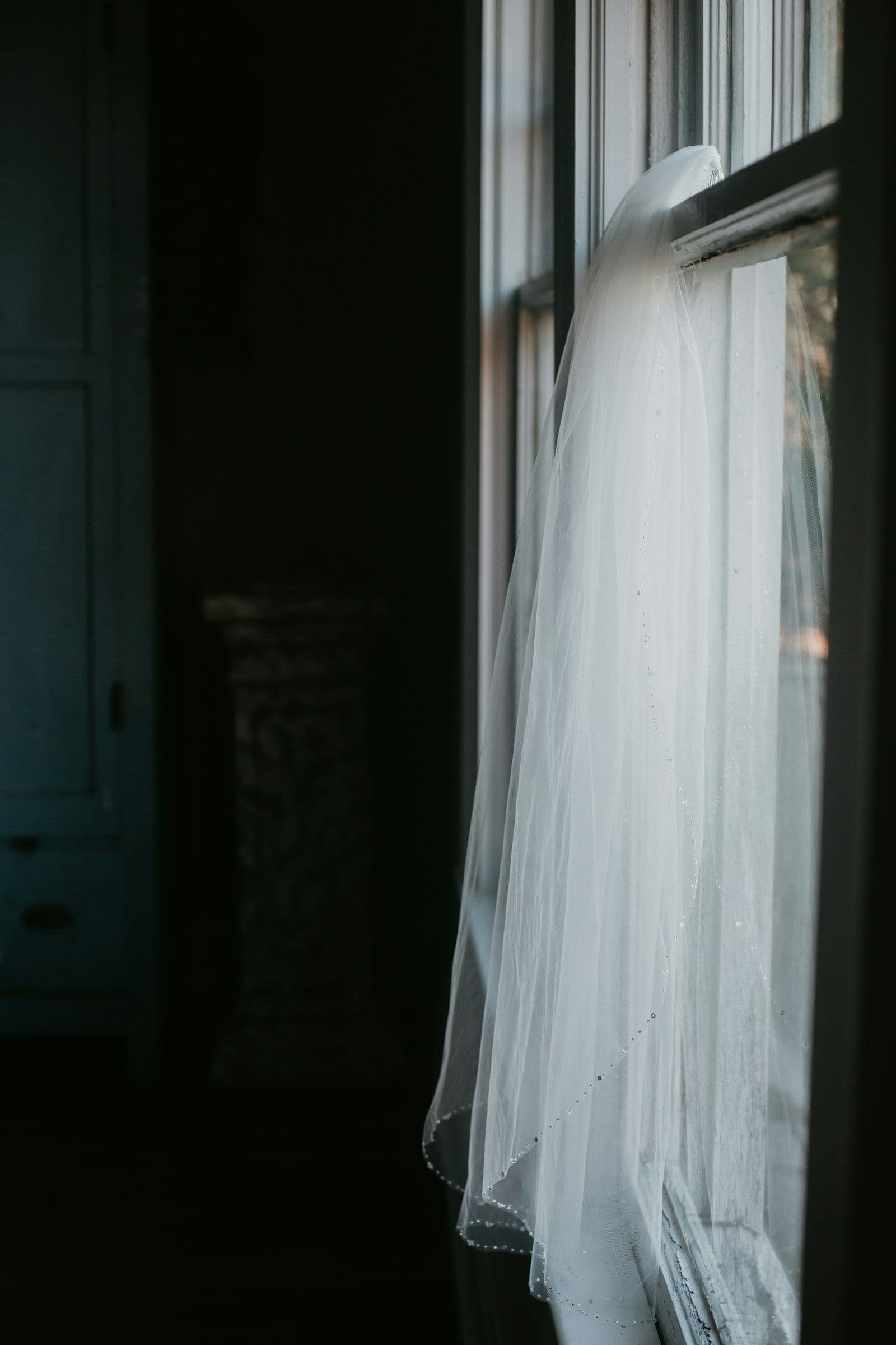 The gown hanging in soft window light